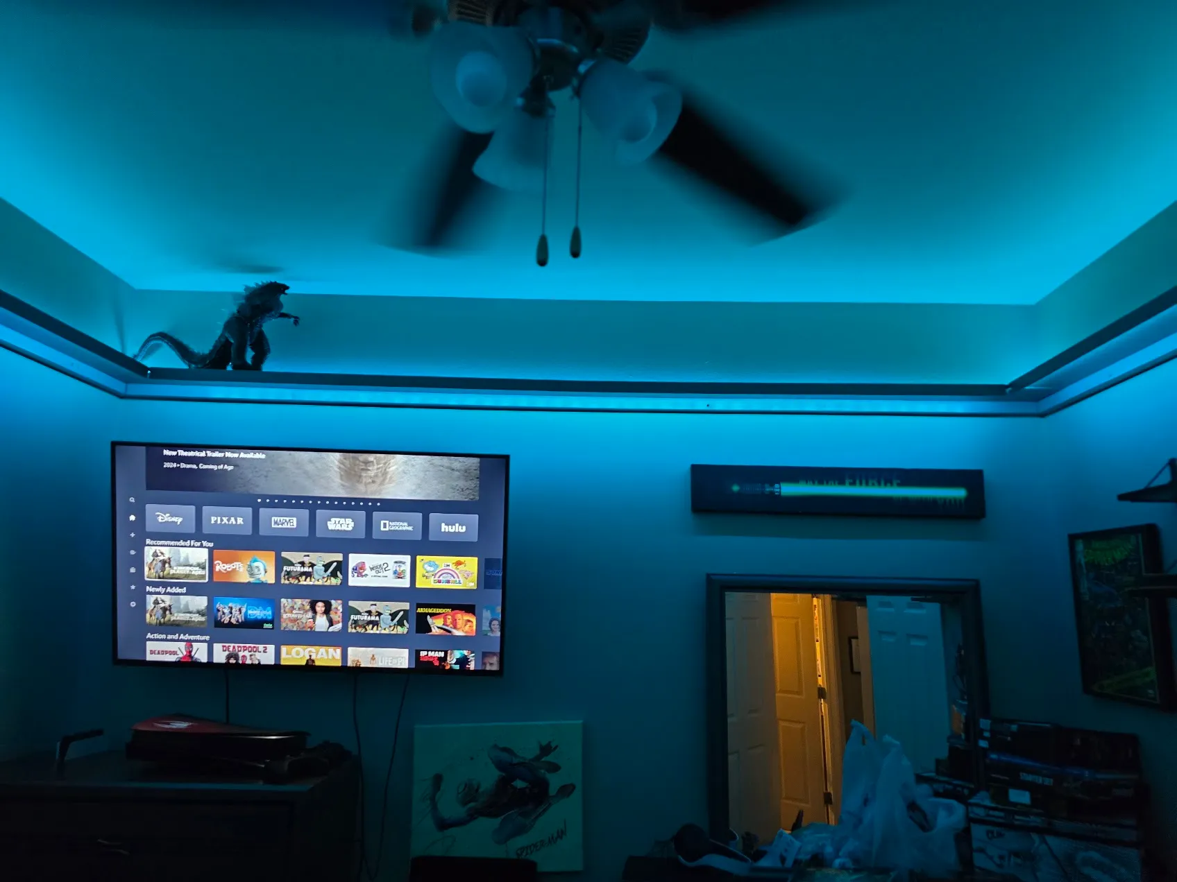 LED-lit floating shelf wrapping around the top of a Star Wars-themed bedroom, with a Godzilla figure displayed on it