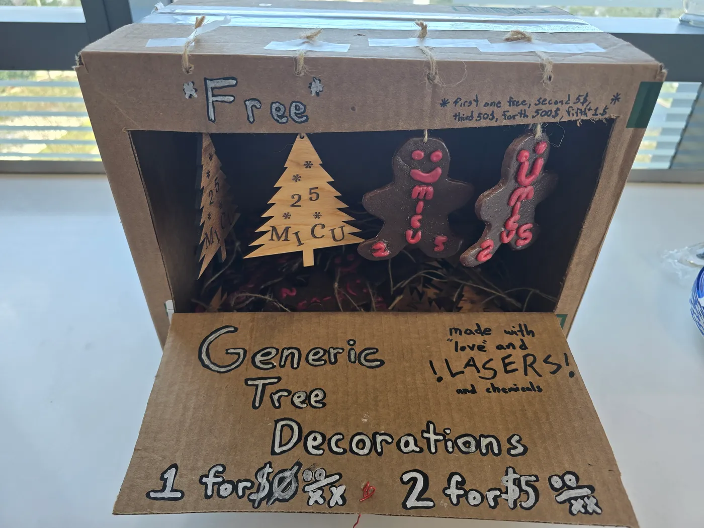 Cardboard gift-shop display box with laser-cut wood trees and epoxy gingerbread ornaments made for MICU staff