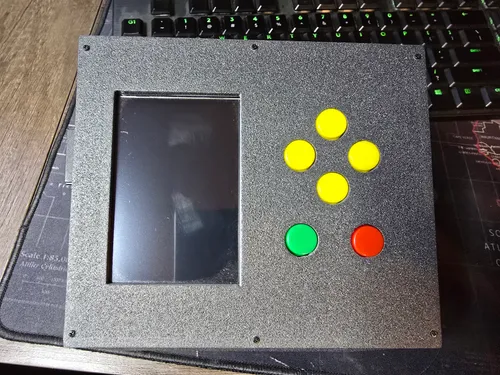 Top panel of the finished enclosure with the screen window, yellow direction buttons, and green and red buttons