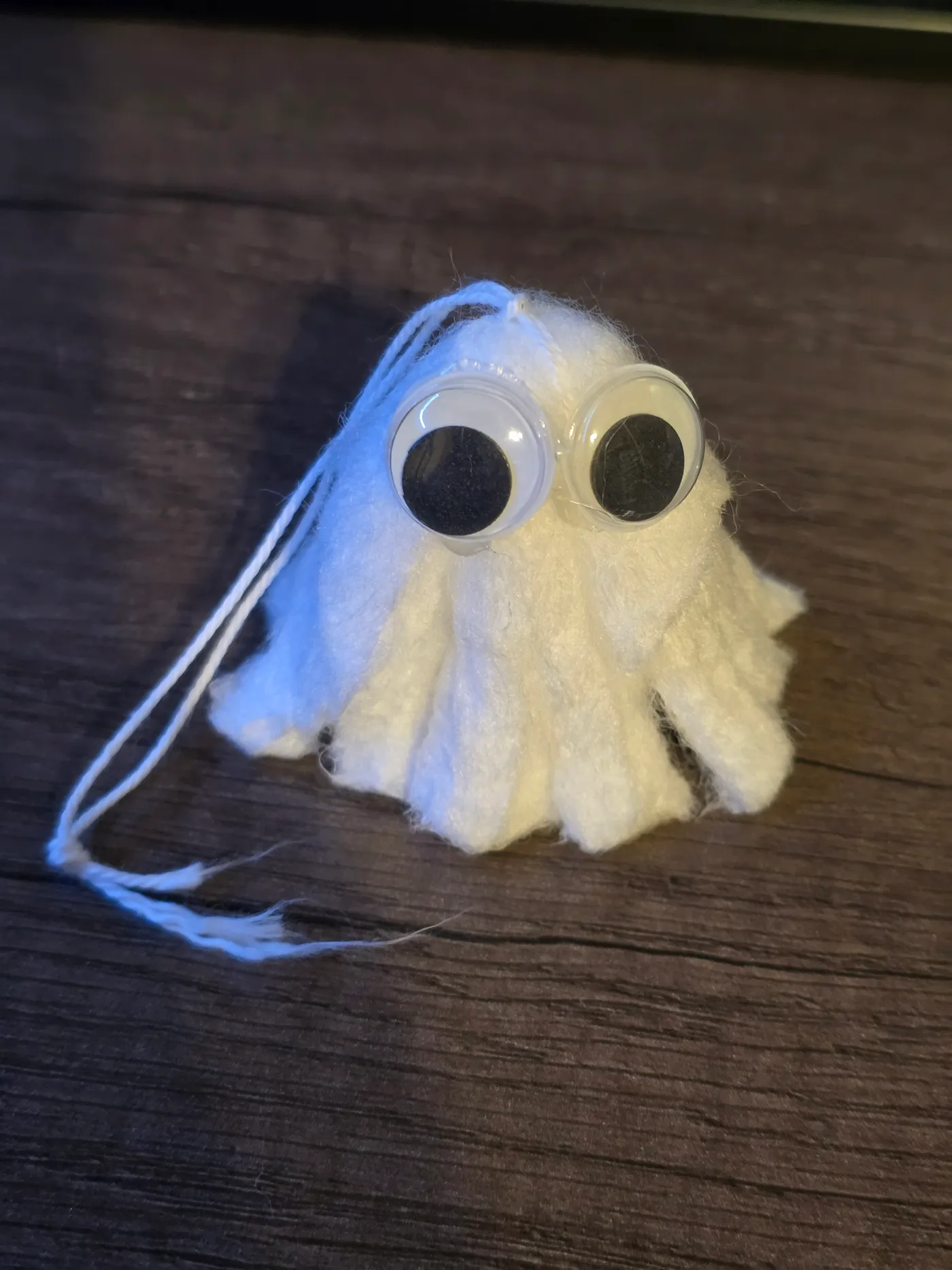 Finished tampon ghost with googly eyes hanging by its string