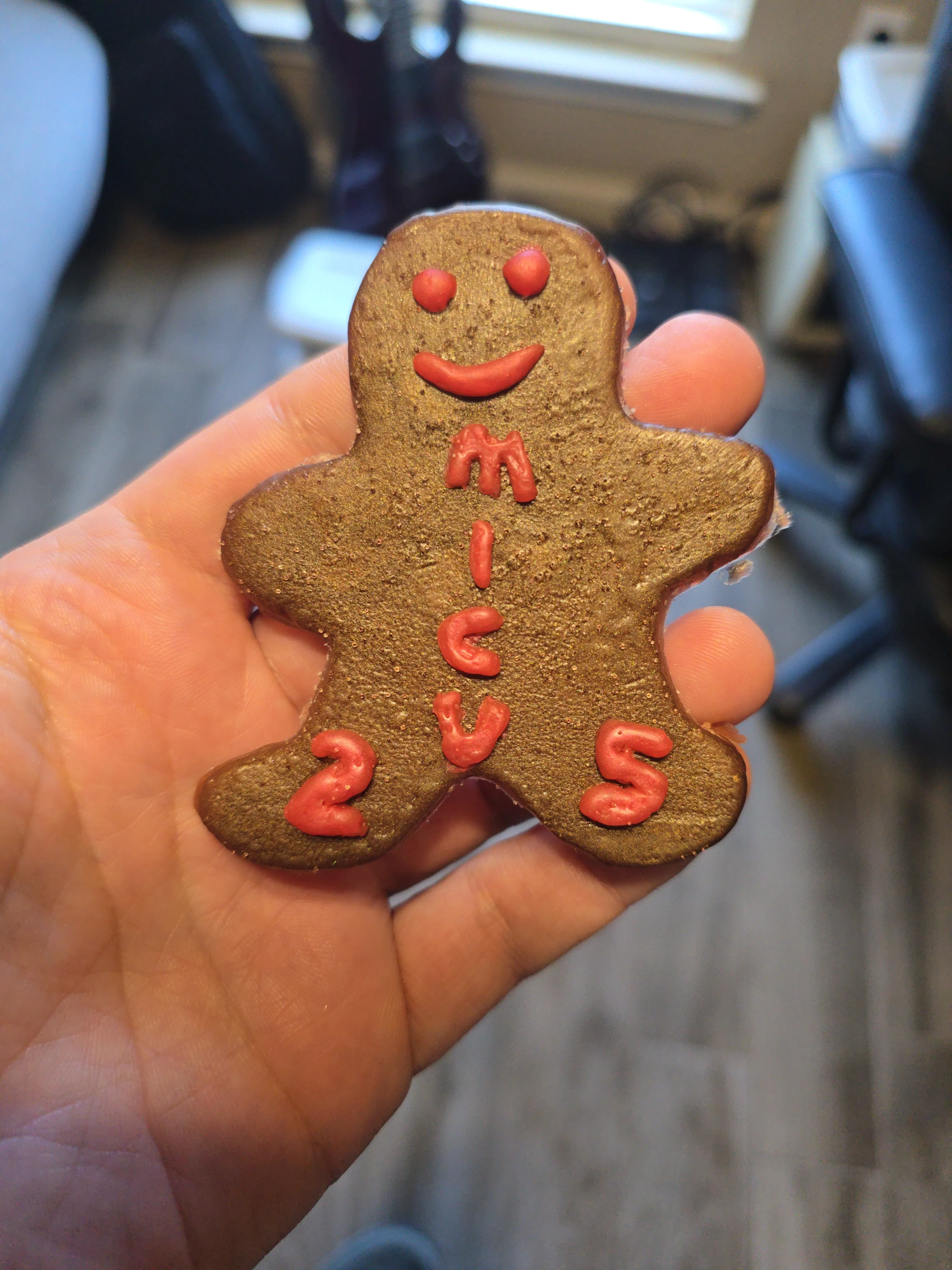 Finished gold-toned epoxy gingerbread ornament with a smiley face and MICU 25 lettering