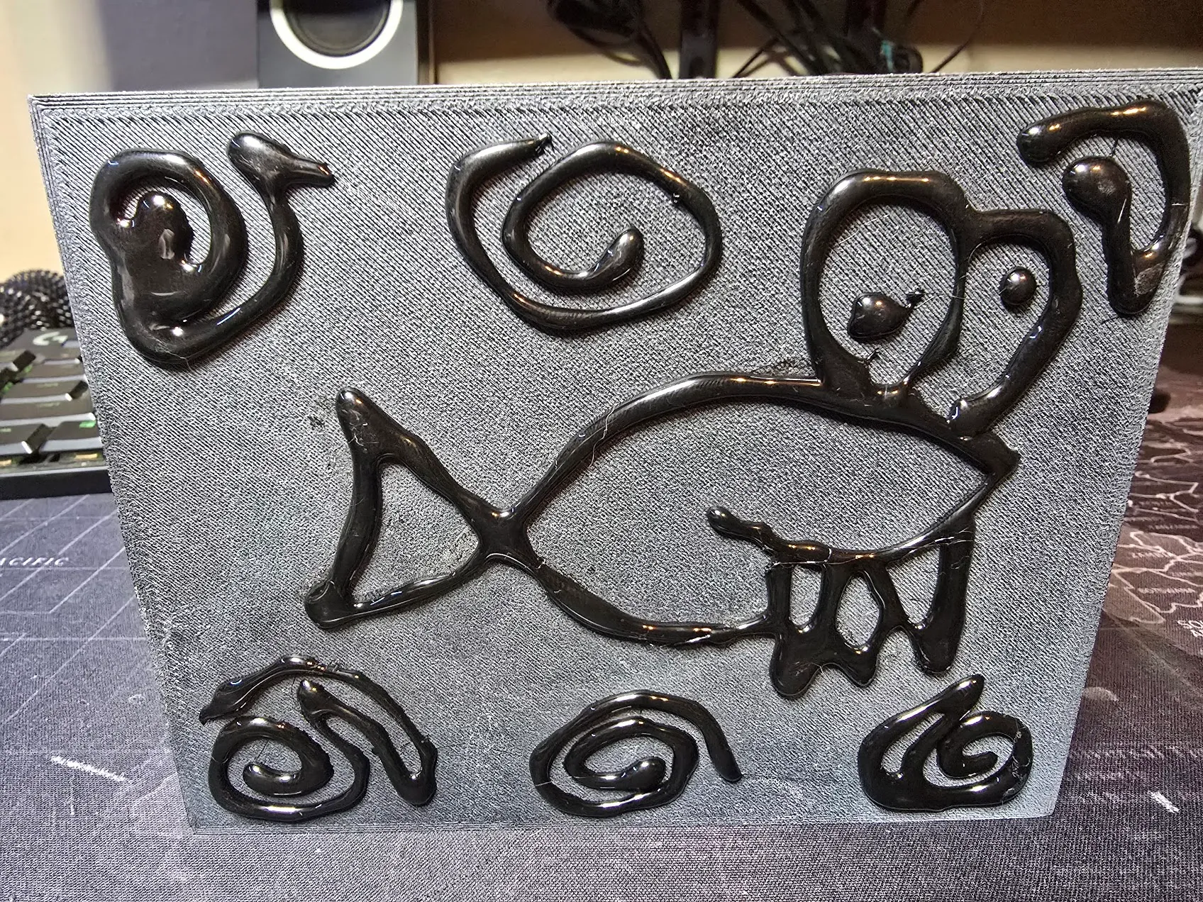 The underside of the enclosure with hot-glue grip lines drawn as the mascot fish surrounded by bubbles