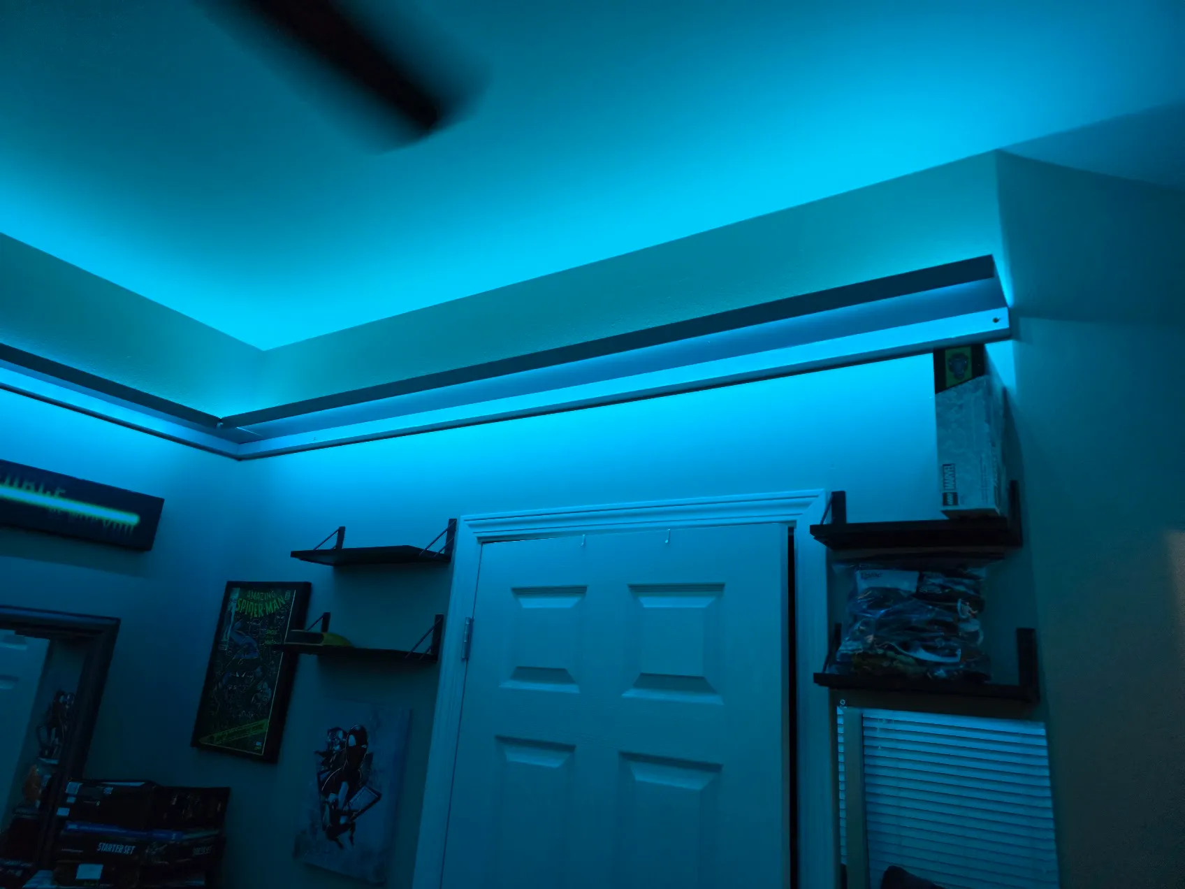 Close-up of the floating shelf turning a corner, lit blue from LEDs above and below